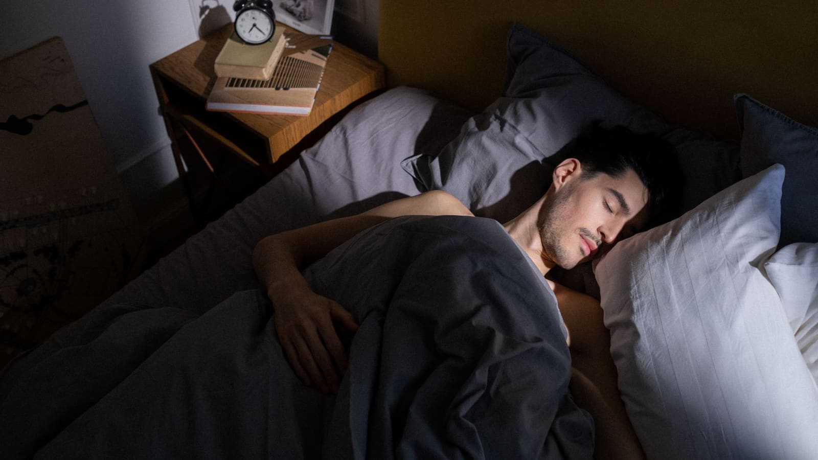 A dimly lit room with a glowing screen casting soft blue light across an empty couch, evoking quiet nighttime viewing
